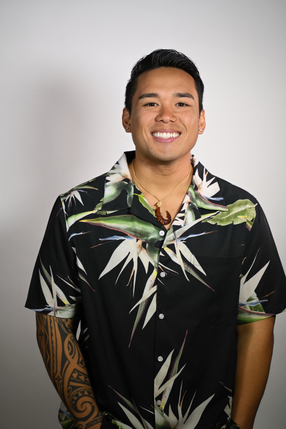 Tre Zamora, smiling in a black bird-of-paradise aloha shirt